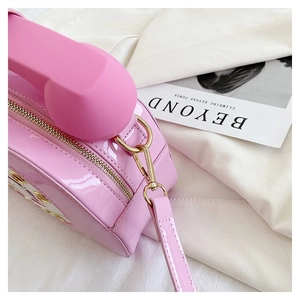 Detail of pink retro telephone bag featuring glossy patent leather and gold zipper