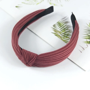 Macro detail of red knitted fabric texture and twisted knot design on fashion headband