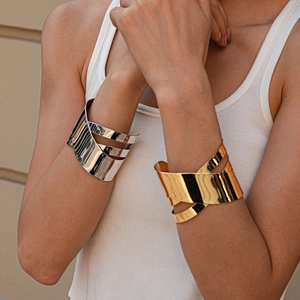 Gros plan de bracelets géométriques entrelacés en or et argent polis sur un mannequin