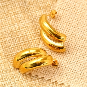Modern chunky 18k gold plated double hoop earrings on a textured beige background