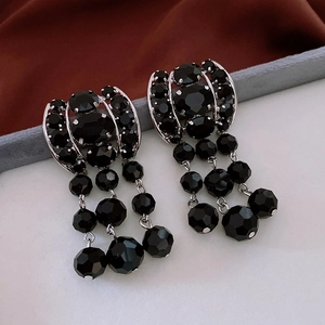 Detailed macro view of black faceted glass bead tassel earrings with vintage silver finish