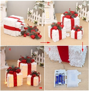 Detailed views of lighted white flocked Christmas gift boxes with red bows and LED battery box