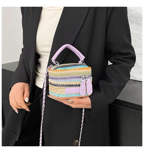 Dettaglio mini borsa intrecciata a righe con tracolla a catena viola e logo moda