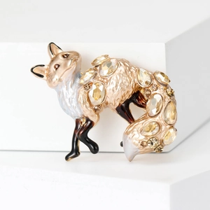 Close-up of golden fox brooch featuring champagne crystals and fine enamel details
