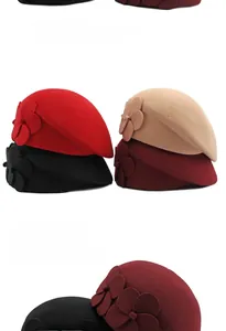 Detail view of wool beret set in four colors with decorative dimensional floral accents