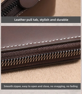 Detail of brown leather card holder featuring white contrast stitching and durable metal zipper