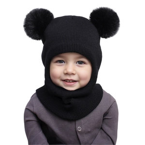 Detail of black knit baby hat with dual faux fur pom-poms and integrated neck warmer