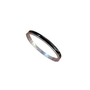 Minimalist silver stainless steel bangle with black enamel inlay on white background