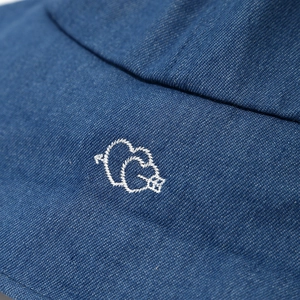 Makroaufnahme eines blauen Denim-Fischerhuts mit weißer Doppelherz-Stickerei