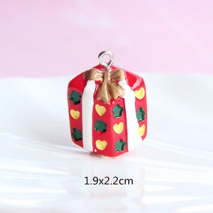 Detailed view of red gift box resin pendant with golden bow for DIY jewelry making