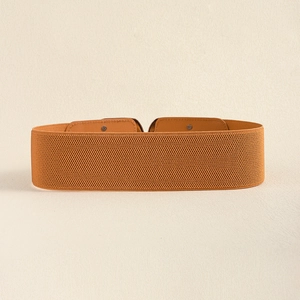 Detail of caramel wide elastic belt featuring thick woven texture and metal rivets