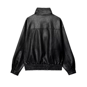 Detail view of the textured back and ribbed hem on a classic black PU leather jacket