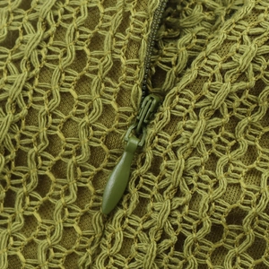 Close-up of olive green knitted maxi dress with hidden zipper and fringe details