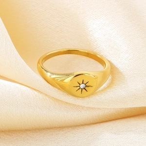 Detailed macro view of 18K gold plated stainless steel starburst ring on silk