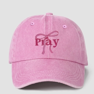Detail of pink washed cotton baseball cap with Pray text and bow ribbon pattern
