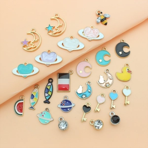 Flat lay of diverse zinc alloy enamel pendants with rhinestones in moon and star shapes