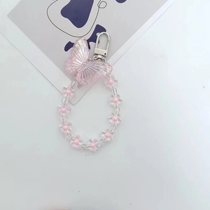 Detail of pink acrylic butterfly pendant with floral bead chain and silver metal clasp