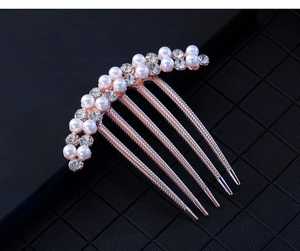 Detail of rose gold hair comb with white faux pearls and clear rhinestones close-up