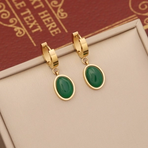 Elegant gold stainless steel earrings featuring oval emerald stones on a beige velvet base