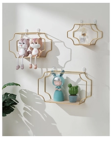 Detail of gold geometric iron wall shelves with wood base and decorative shadow