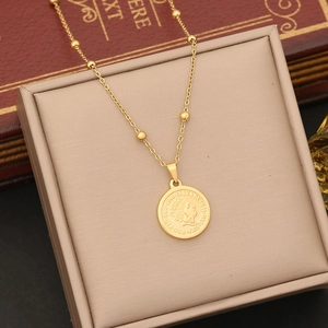 Detailed macro of gold coin pendant with queen relief on a beaded stainless steel chain