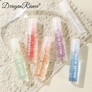Set of six colorful rollerball lip glosses with shimmer finish on a glass tray