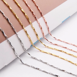 Detailed view of twisted spiral necklace chains in gold, silver, and rose gold finishes