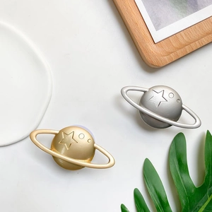 Macro view of metallic planet-shaped phone sockets in gold and silver with star embossing