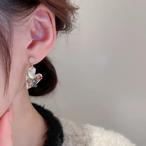 Detail shot of heart-shaped crystal earrings with colorful mosaic patterns on a model
