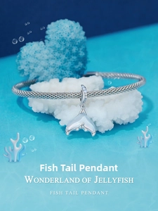Macro detail of silver fishtail pendant with opal inlay and zircons on ocean theme