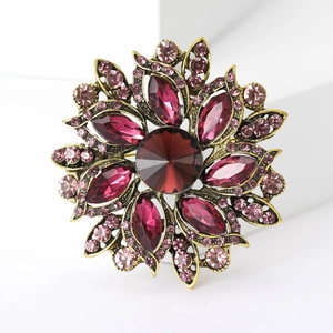 Detailed macro view of vintage flower brooch with faceted red crystal and gold alloy