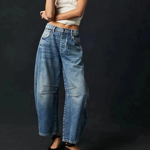 Détail du jean large bleu en denim avec coupe décontractée et textures plissées