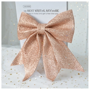 Macro detail of rose gold glitter bow with double-layered loops and swallowtail ribbons