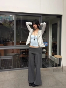 Detailed view of casual three-piece outfit with white hoodie and grey wide-leg trousers