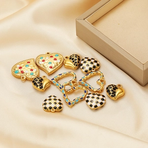 Macro shot of stainless steel heart pendants with enamel patterns on gold satin base
