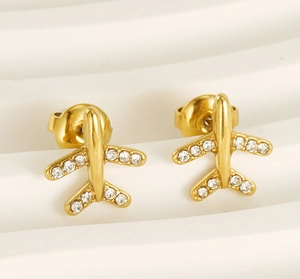 Vue macro de boucles d'oreilles avion en acier doré avec cristaux et finition 18 carats