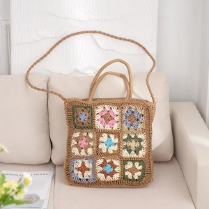 Colorful granny square crochet tote bag with woven shoulder strap and top handles