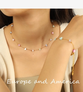 Close-up of 18k gold plated stainless steel necklace and bracelet set with colorful stars