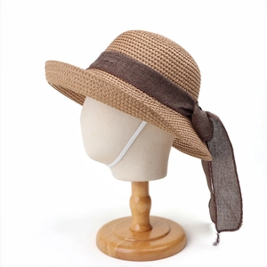 Detail of child straw sun hat with large brown chiffon bow and elastic wind rope