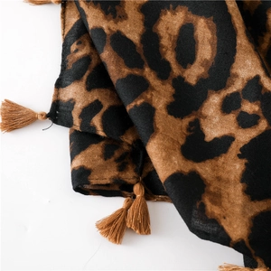 Detail of leopard print scarf showing soft texture and handmade brown tassel edges