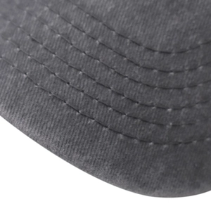 Macro view of reinforced stitching on washed cotton brim of dark grey baseball cap