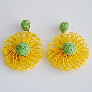 Detail of yellow and green raffia flower earrings showing the handwoven woven texture