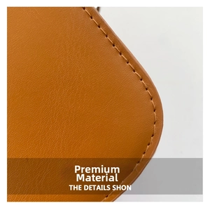 Close-up of caramel brown pebble leather texture and fine stitching on a shoulder bag