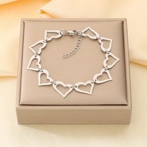 Detailed shot of silver hollow heart link chain bracelet on a silk jewelry box