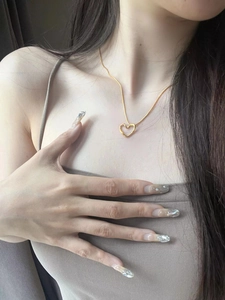 Close-up of minimalist gold twisted heart pendant necklace worn on a model's neck