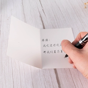 Elegant gold-stamped greeting card with writing pen on a rustic wooden background