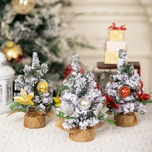 Three mini frosted Christmas trees with burlap bases and festive ornaments for home decor
