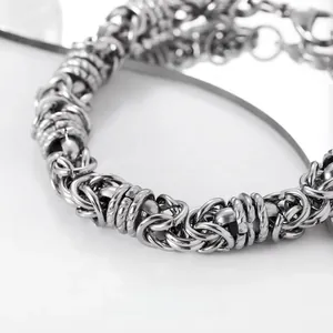 Vue macro détaillée d'un bracelet gourmette argenté au design industriel et poli