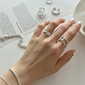 Detail view of 925 sterling silver chain link rings and bracelet on female hand