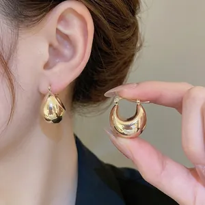 Elegant chunky gold-plated C-shaped hoop earrings with a minimalist metallic finish